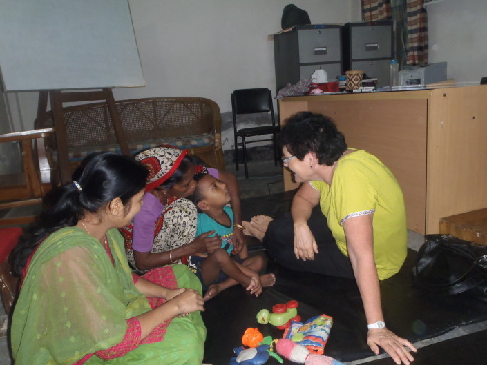foto van Ria die een patient onderzoekt met de moeder in de pcc daycare in Bangladesh